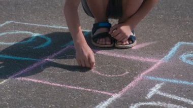 Çocuk üzerinde seksek asfaltta sekiz numara çizer.