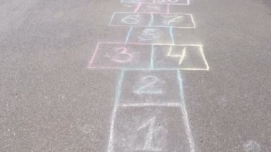 Park asfalt üzerinde seksek oyunu. Renkli mangası ile boyalı.