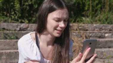 Görüntülü sohbet telefonda: çağrı, söz ve gülümseyen genç kadın.