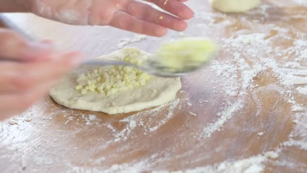 Les mains des femmes font une tarte avec du riz et des œufs à partir de pâte à levure sur la table de cuisine. Gros plan . — Video