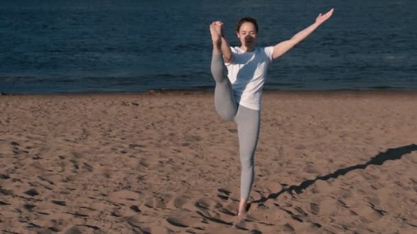 Şehrin nehir kenarında kumsalda Yoga esneme kadın. Güzel bir şehir manzarası. Utthita Hasta Padangushthasana poz. — Stok video