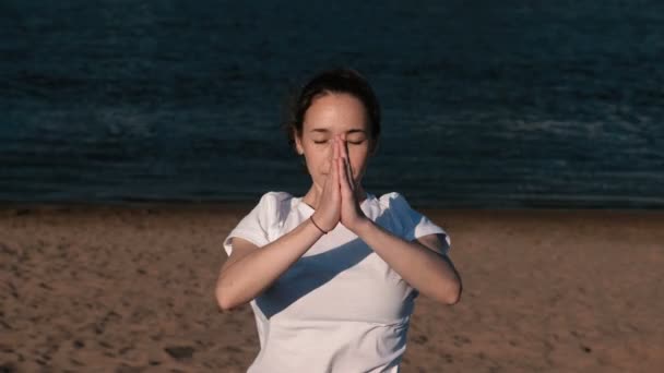 Femme étirant le yoga sur la plage au bord de la rivière dans la ville. Belle vue sur la ville. pose Namaste . — Video