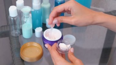 Kadın el kremi bir spatula ile küçük bir büyük kavanozdan koyun. Kozmetik yol kümesi. Yakın çekim kavanoz.
