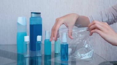 Bayan Kozmetik şişe ve kavanozlar ile yol kümesi bir ZIP Plastik çanta içinde ellerini. Yakın çekim kavanoz.