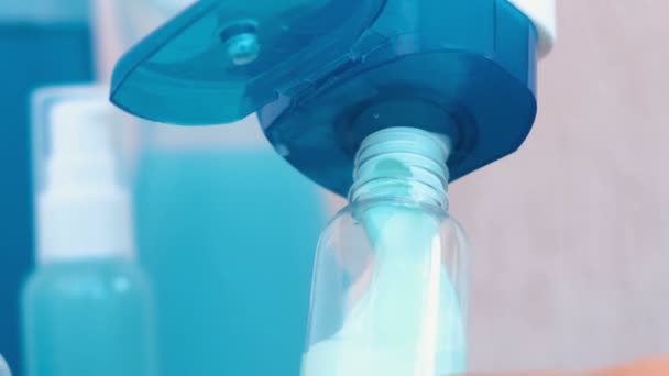 Zenske rukou nalít modrý šampon v malé lahvičce velkých. Cestovní sada sklenic. Láhev detail. — Stock video