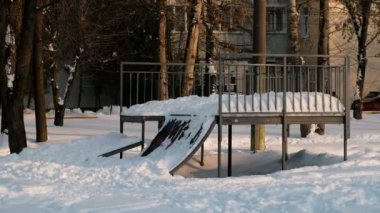 Karlı güneşli kış city Park yatılı park paten. Üstünde belgili tanımlık tepe kaykay kar sürüklenir.
