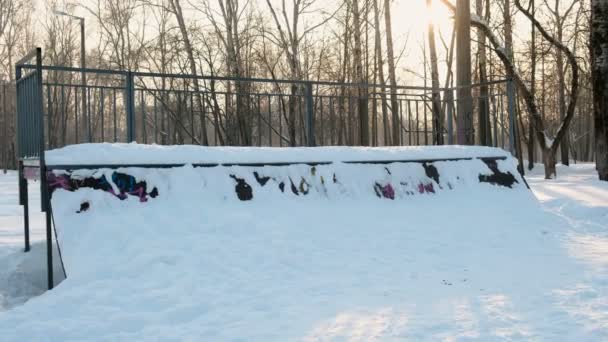 Parque de skate en la nieve. La nieve se desplaza en la colina para patinar . — Vídeo de stock