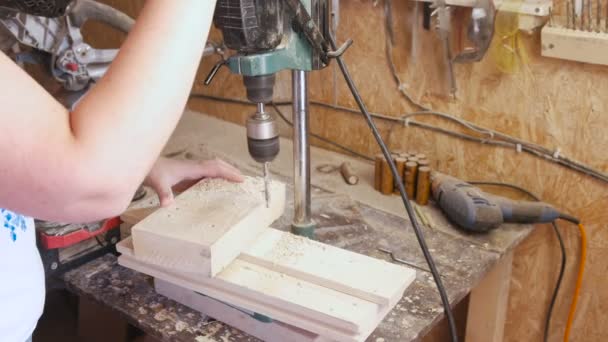 Werknemer boren gaten in de houten sjablonen. Vervaardiging van houten speelgoed. Close-up handen. — Stockvideo