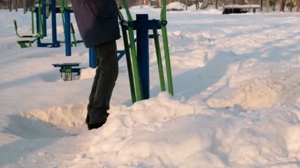 Närbild Mans Ben Gör Övningar Simulator Winter Park Staden Bakifrån — Stockvideo