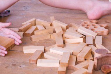 Çocuk ahşap zemin üzerinde ahşap oyuncak piramit ev şeklinde from birçok ayrıntıları ile oynuyor. Tanınmayan çocuk. Yakın çekim el