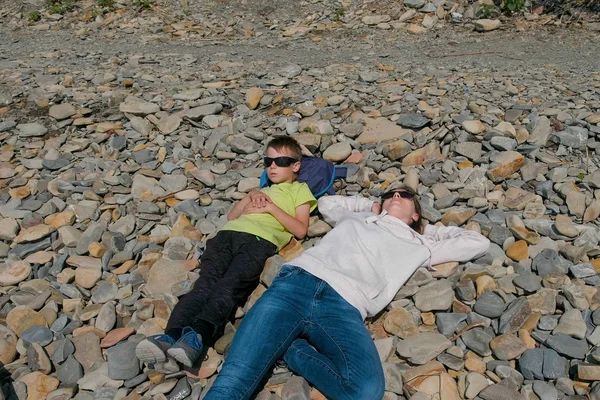 Madre e hijo descansando tendidos sobre las rocas . —  Fotos de Stock