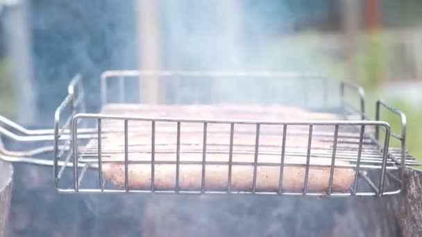 Sausages on the grill rack fried on charcoal. Side view. — Stock Video