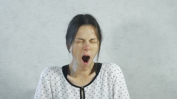 Mujer cansada soñolienta bosteza sobre fondo blanco . — Vídeos de Stock