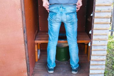 Köyde bir pot ile dış tuvalet adam pees.