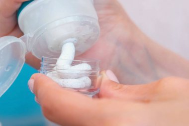Kadın el bir yüz fırçalayın küçük bir kavanoza koy. Kozmetik yol kümesi. Yakın çekim kavanoz.