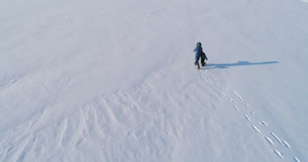 Tid för familjen gå och spela tillsammans. Mor och son kör hand i hand genom snön täckte yta på vintern. Mamma tar son i händer och vänder honom. — Stockvideo