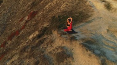 Büyük dağ günbatımı kenarında germe yoga yaparken kadın güzel görünümü.