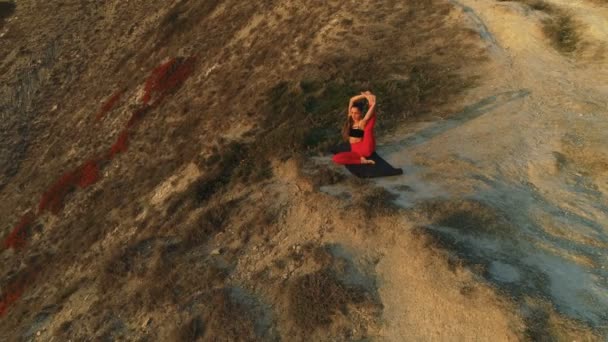 Прекрасний вигляд жінки робить йогу, що тягнеться на краю величезного гірського заходу сонця . — стокове відео
