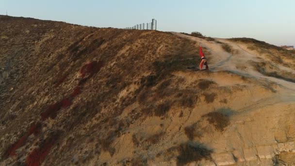 Kvinnan gör yoga på toppen av berget vid solnedgången. Aerial vackra bilder. — Stockvideo