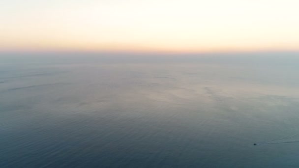 Mooie vrouw doet stretcing van yoga en meditatie op de top van de berg met uitzicht op zee bij zonsondergang. Luchtfoto beeldmateriaal. Achteraanzicht. — Stockvideo