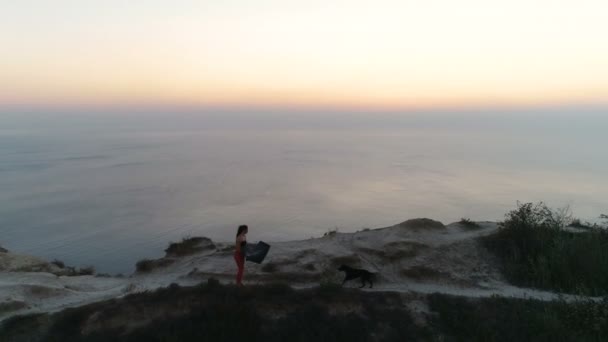 Femme marche sur le bord d'une falaise avec un tapis de yoga . — Video
