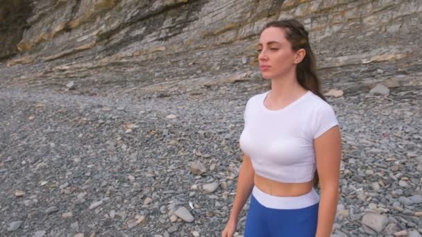 Flachen Bauch Mädchen während Zwerchfell Atemübungen Bodyflex auf dem Felsen Hintergrund. Nahaufnahme von Gesicht und Körper. — Stockvideo