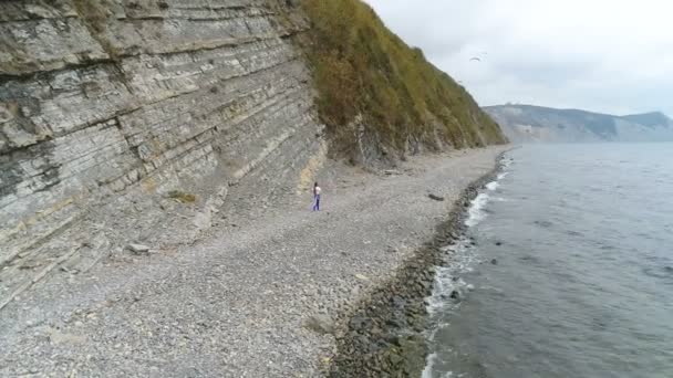 Kvinnan gör yoga och fysiska övningar på rock och havet bakgrund. Aerial vackra footage sidovy. — Stockvideo