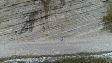 Kadın rock ve deniz arka plan üzerinde yoga ve stretcing egzersizleri yapıyor. Hava güzel görüntüleri yan görünüm.