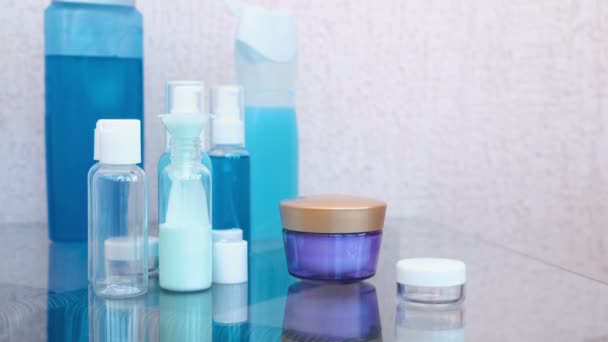 Giet blauw shampoo in een klein flesje van grote via een trechter. Reis set van potten. Flessen cosmetica close-up. — Stockvideo