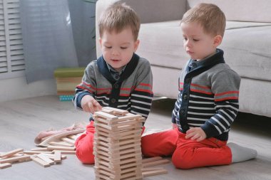 İkiz erkek kardeşleri tarafından kendi odasında kanepe katta oturan tahta bloklarla inşa ediyoruz.