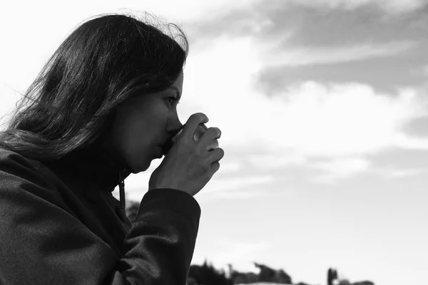 A mulher está a beber chá à beira-mar. Morena jovem em uma viagem. Bw... . — Fotografia de Stock