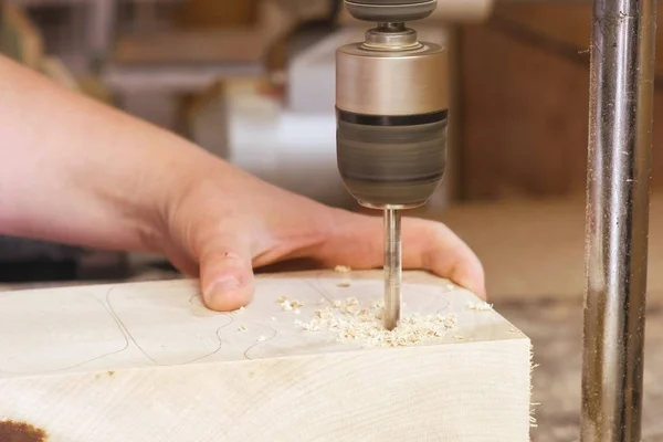 Travailleur perce des trous dans les modèles en bois. Fabrication de jouets en bois. Gros plan mains . — Photo