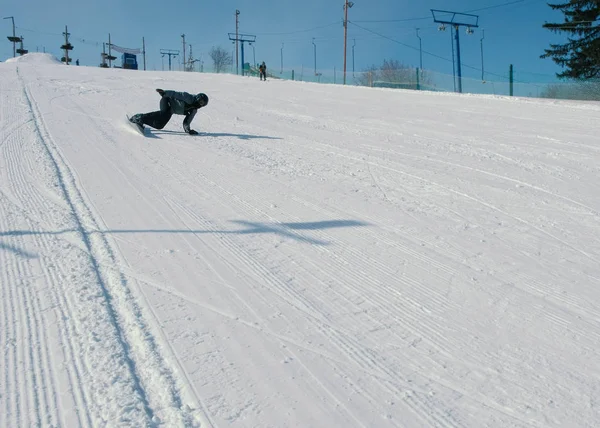 Adolescente de 12 anos deslizando em um snowboard de descida de neve próximo elevador de céu . — Fotografia de Stock