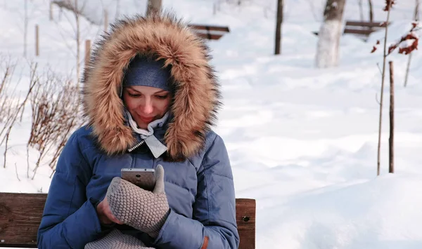 Женщина Сидит Скамейке Просматривает Мобильный Телефон Зимнем Парке Городе Солнечный — стоковое фото