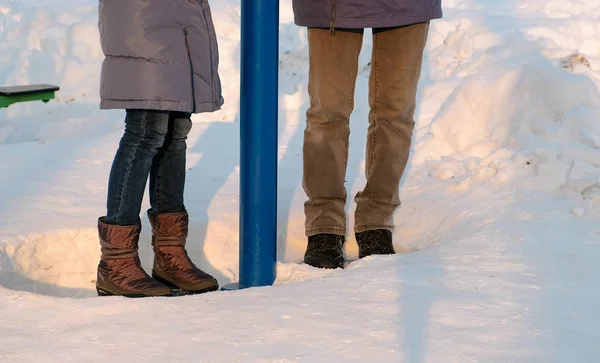 Крупным планом мужчины и женщины занимаются симуляторами в дрифтах в зимнем парке. Вид сбоку — стоковое фото
