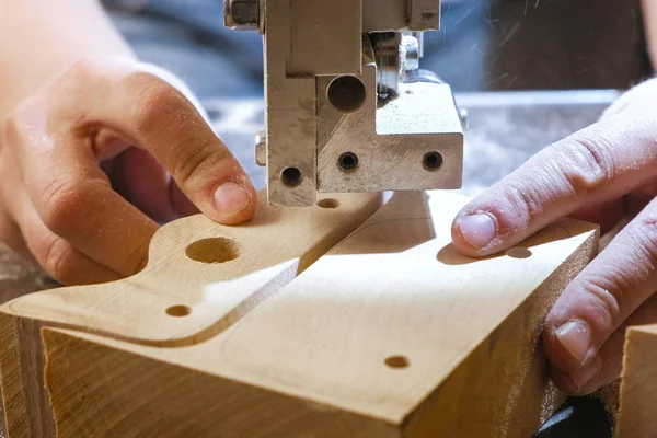 Craftswoman ahşap bir parça odundan şerit testere ile kesme. Yakın çekim yakışıklı.