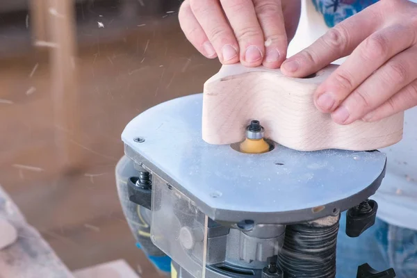 Charpentier faire une partie en bois sur une fraiseuse manuelle. Gros plan mains . — Photo
