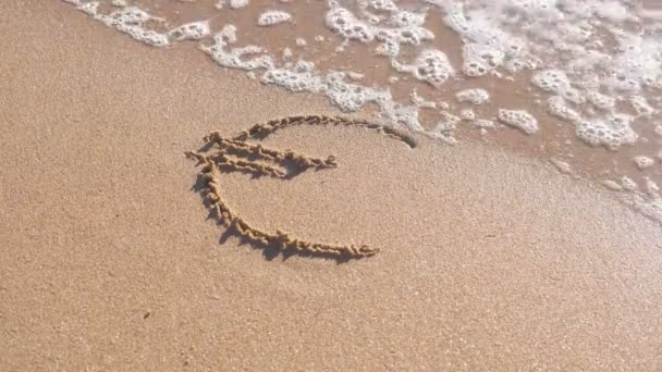 Euro signe écrit dans le sable de la mer. Les vagues ont lavé l'inscription . — Video