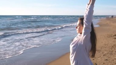 Kadın uzanan kum plaj dalgalar ile yoga yaparken, yan görünüm.