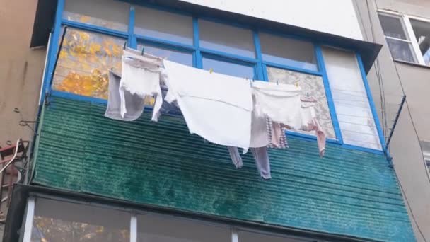 Concepto de vida de pobreza. Ropa de cama se seca en el balcón en la calle . — Vídeos de Stock