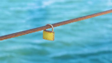 Rusty Padlock demir tel deniz su arka plan üzerinde asılı.