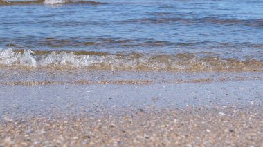 Küçük dalgalar ile kum plaj. Güzel deniz manzarası.