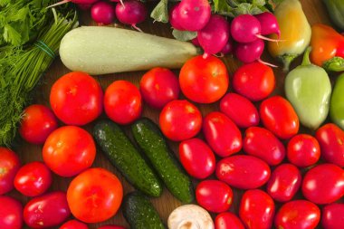 Taze sebze domates, salatalık, kabak, biber, yeşillik, turp ve mantar mutfak masasında.