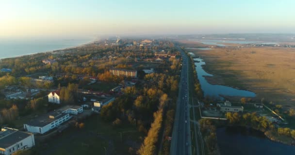 Beautiful evening view of coastal city with roadway and wet meadows. — Stock Video