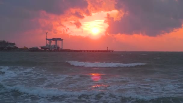 Bellissimo paesaggio marino con tramonto rosso, porto marittimo con navi e onde di tempesta in serata . — Video Stock