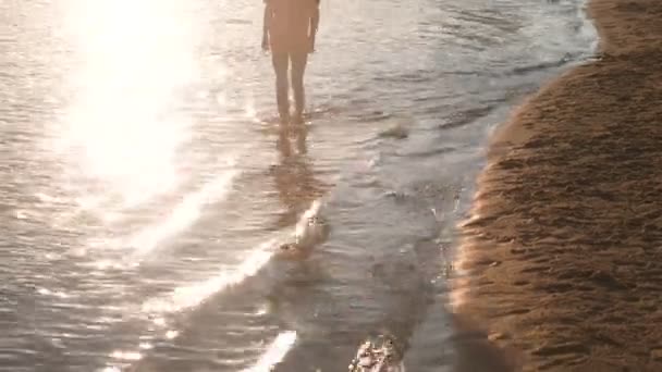Garçon méconnaissable dans un t-shirt rouge marche sur l'eau de la rivière . — Video