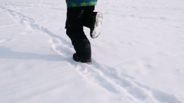 Närbild pojkar ben kör genom snön — Stockvideo