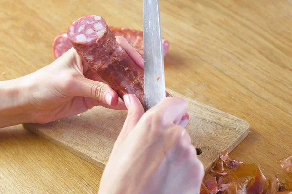 Kadının elleri Tütsülenmiş sosis gelen kabuğu soyma.