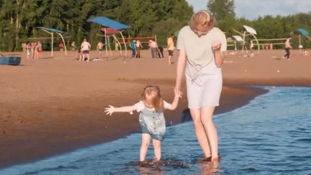 Maman et fille jouant sur la plage de la rivière au coucher du soleil et nager . — Video