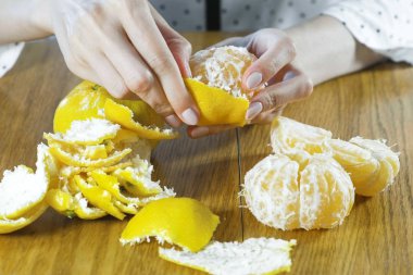 Kadın eliyle bir mandalina kabuğu. Eller yakın çekim.